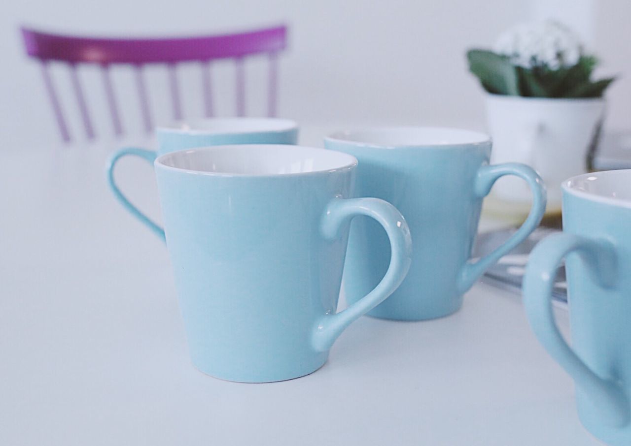 CLOSE-UP OF COFFEE CUP AND TABLE