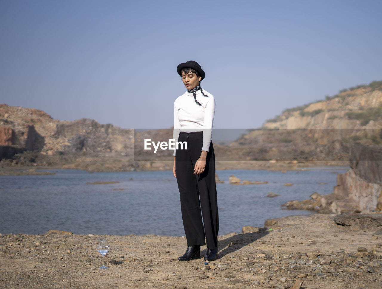 Full length of woman standing by lake against sky