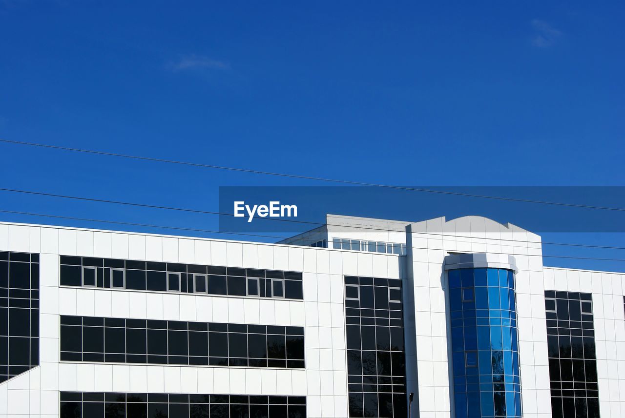 Office building in city against blue sky