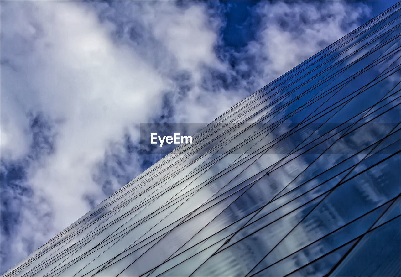 CLOSE-UP LOW ANGLE VIEW OF BUILDING AGAINST CLOUDY SKY