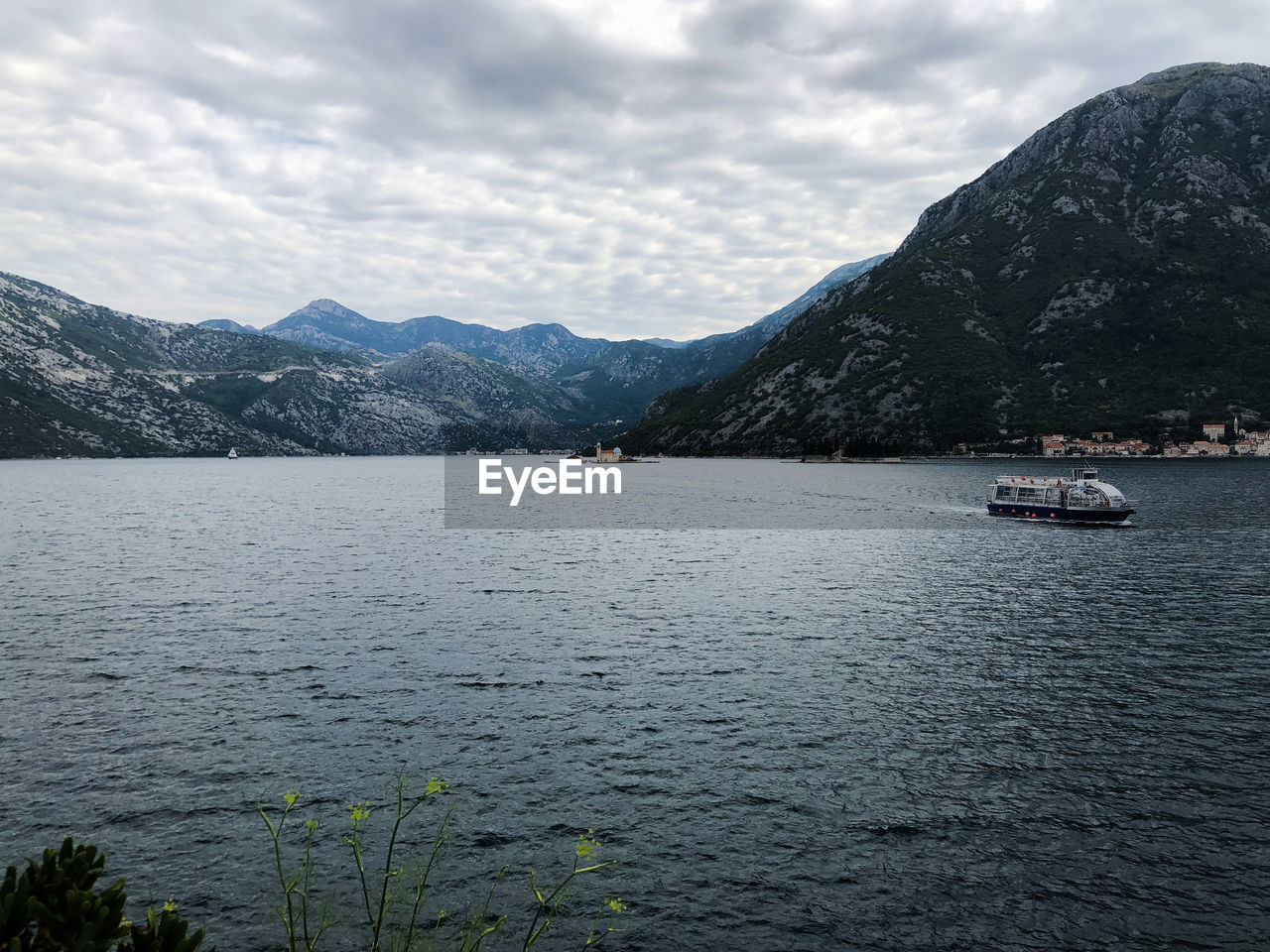 Sailboats in sea against mountains