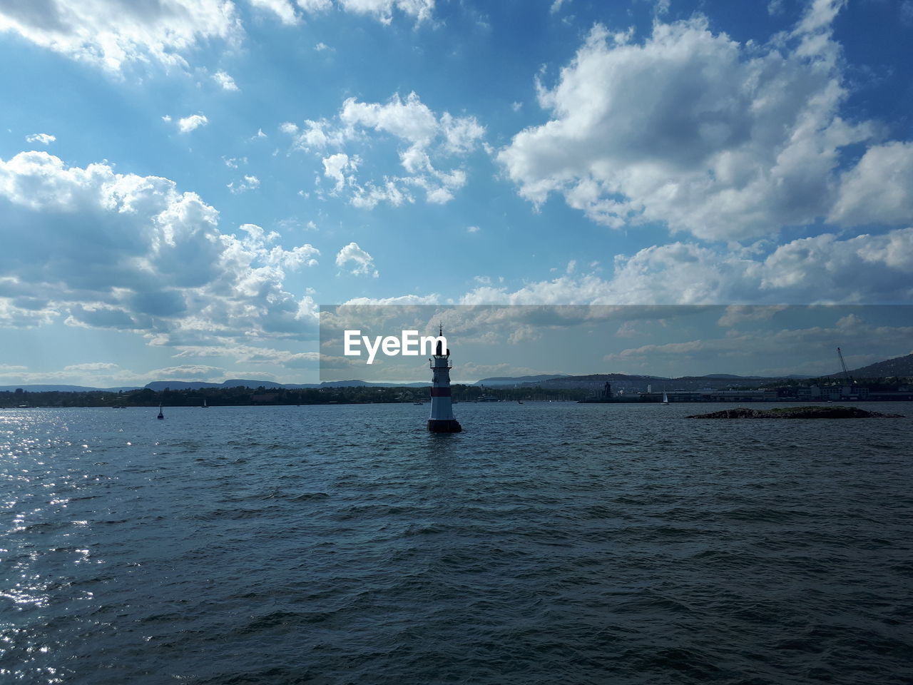 Statue in sea against cloudy sky