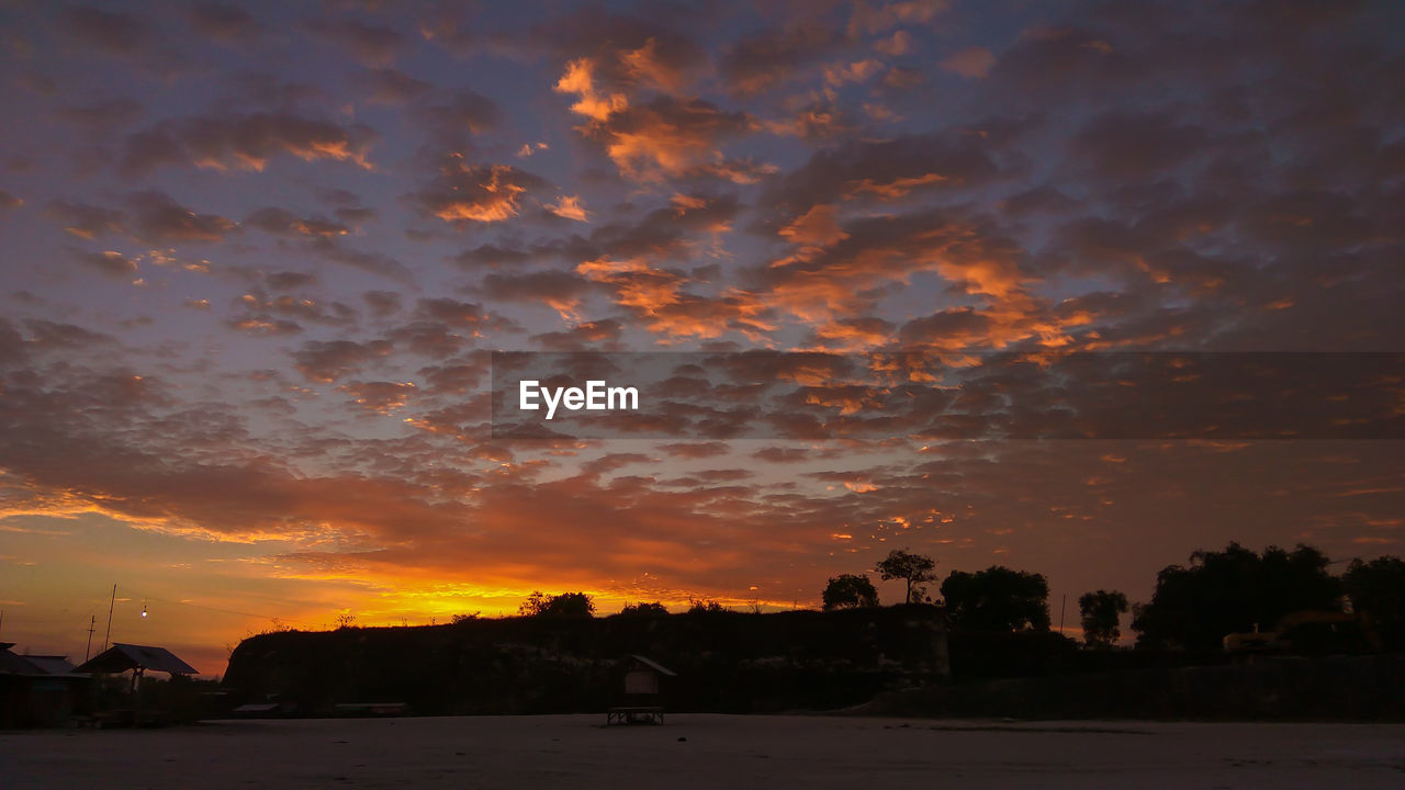 SCENIC VIEW OF DRAMATIC SKY OVER SILHOUETTE BUILDINGS DURING SUNSET