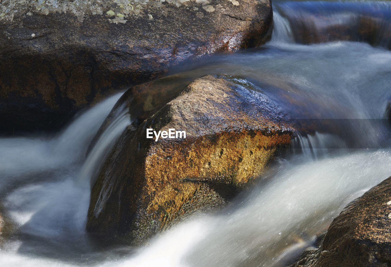 WATER FLOWING THROUGH ROCKS IN RIVER