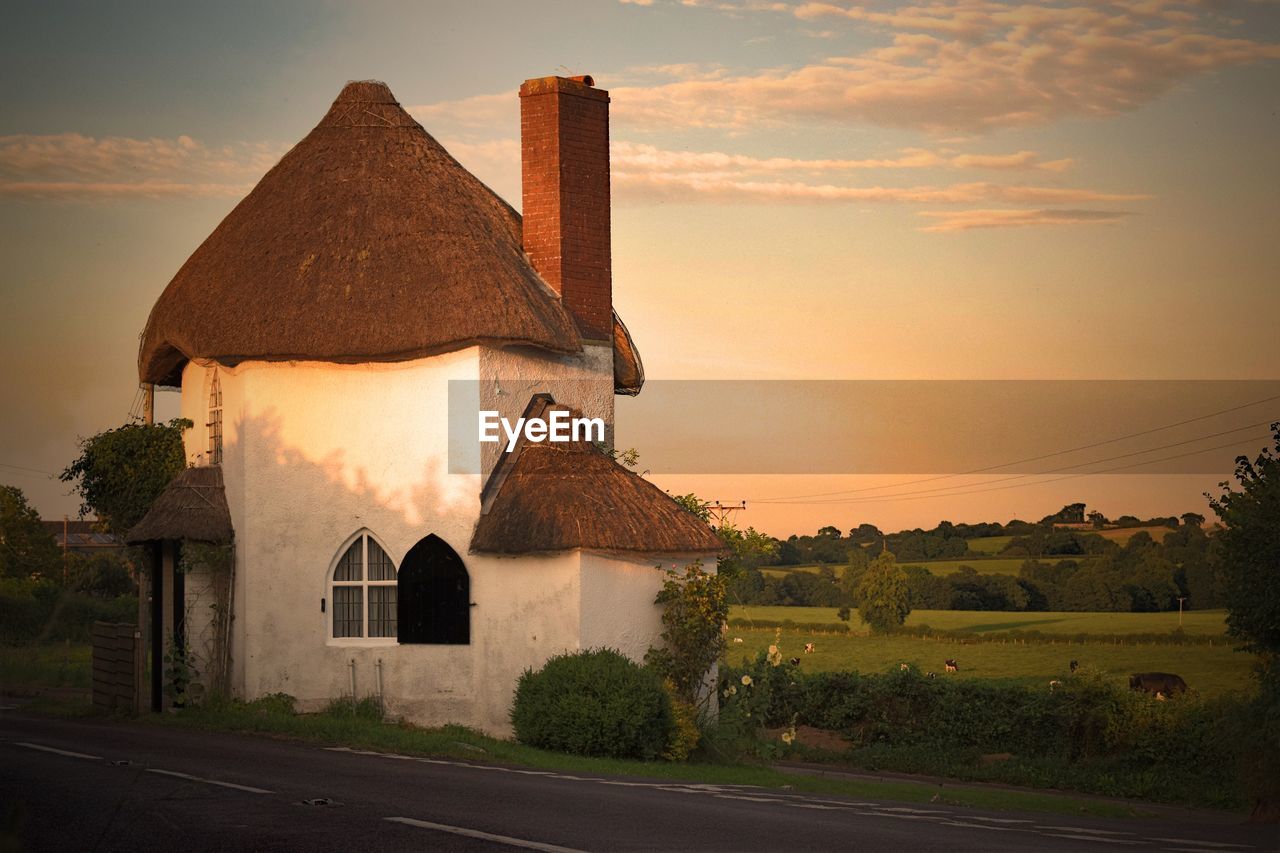 TRADITIONAL HOUSE AGAINST SKY DURING SUNSET