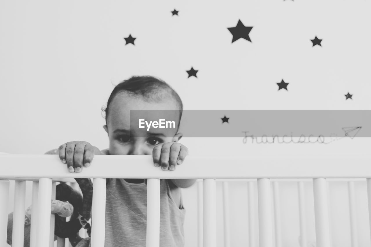 Portrait of baby boy in crib