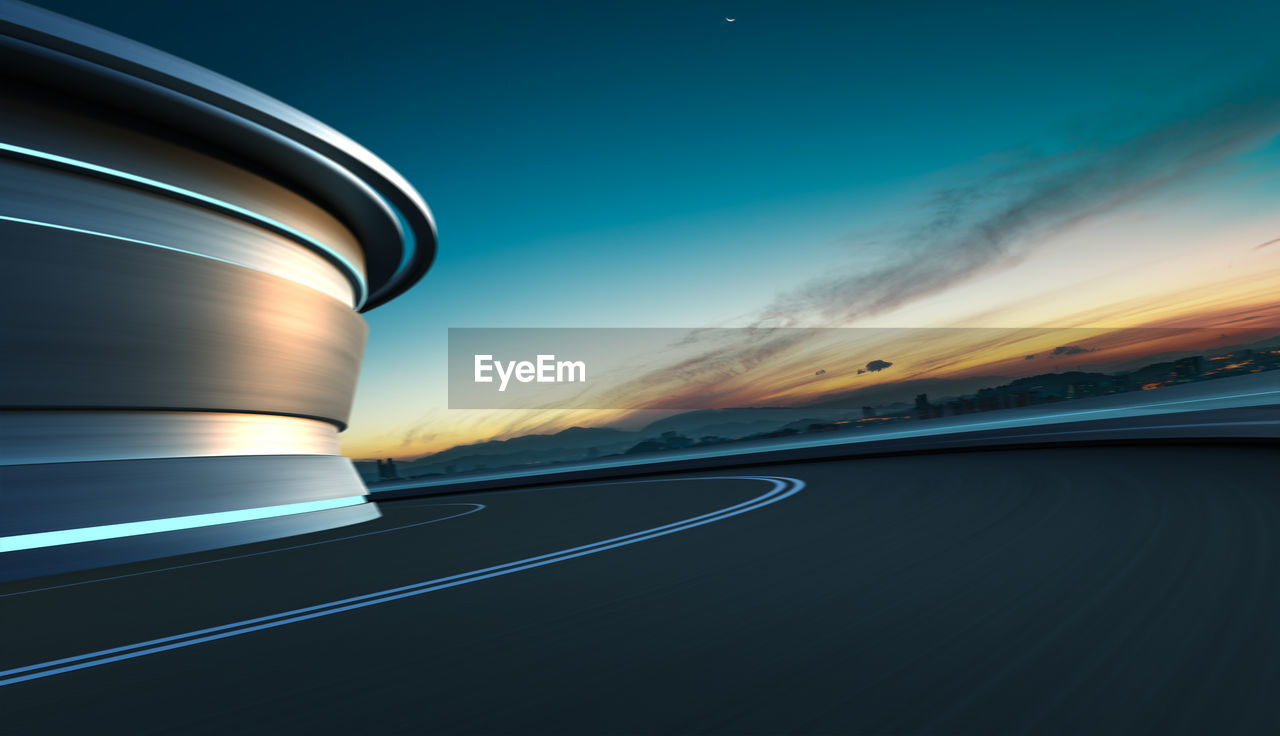 Low angle view of curvy road against sky during sunset