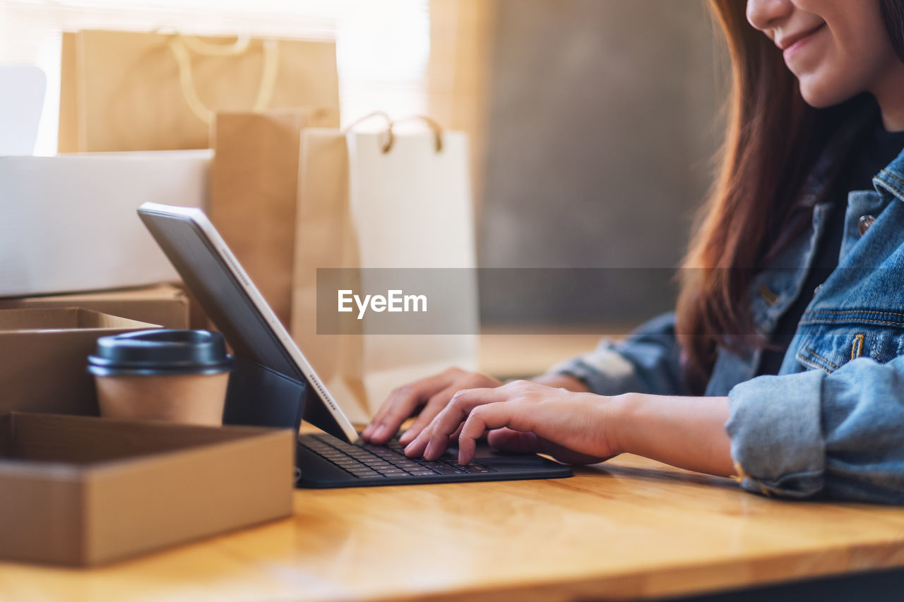 Midsection of woman using laptop on table