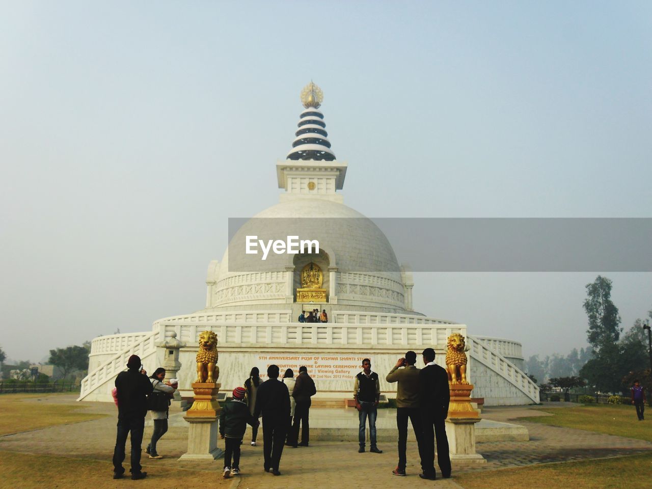 GROUP OF PEOPLE IN FRONT OF BUILT STRUCTURE