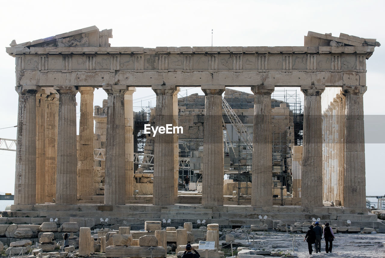 Tourist at ancient parthenon against sky