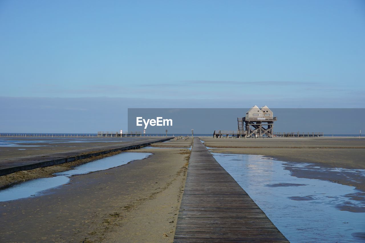 Pier on beach against sky