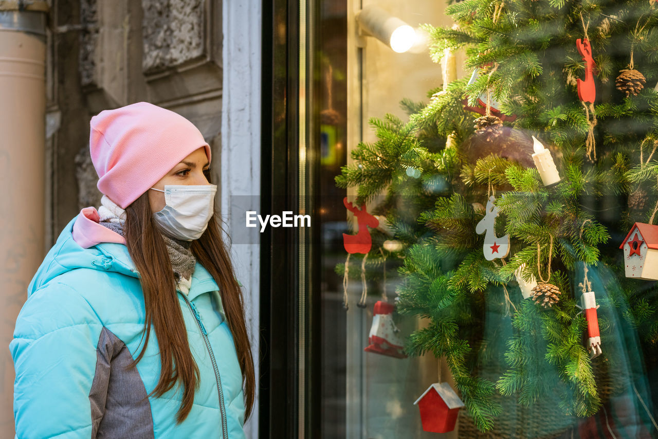 A woman in a protective mask looks at a new year's showcase