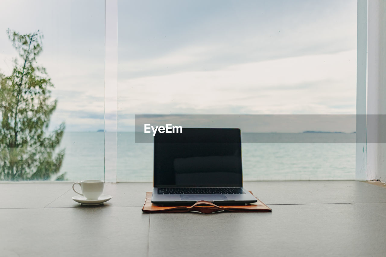 Coffee cup on table against window