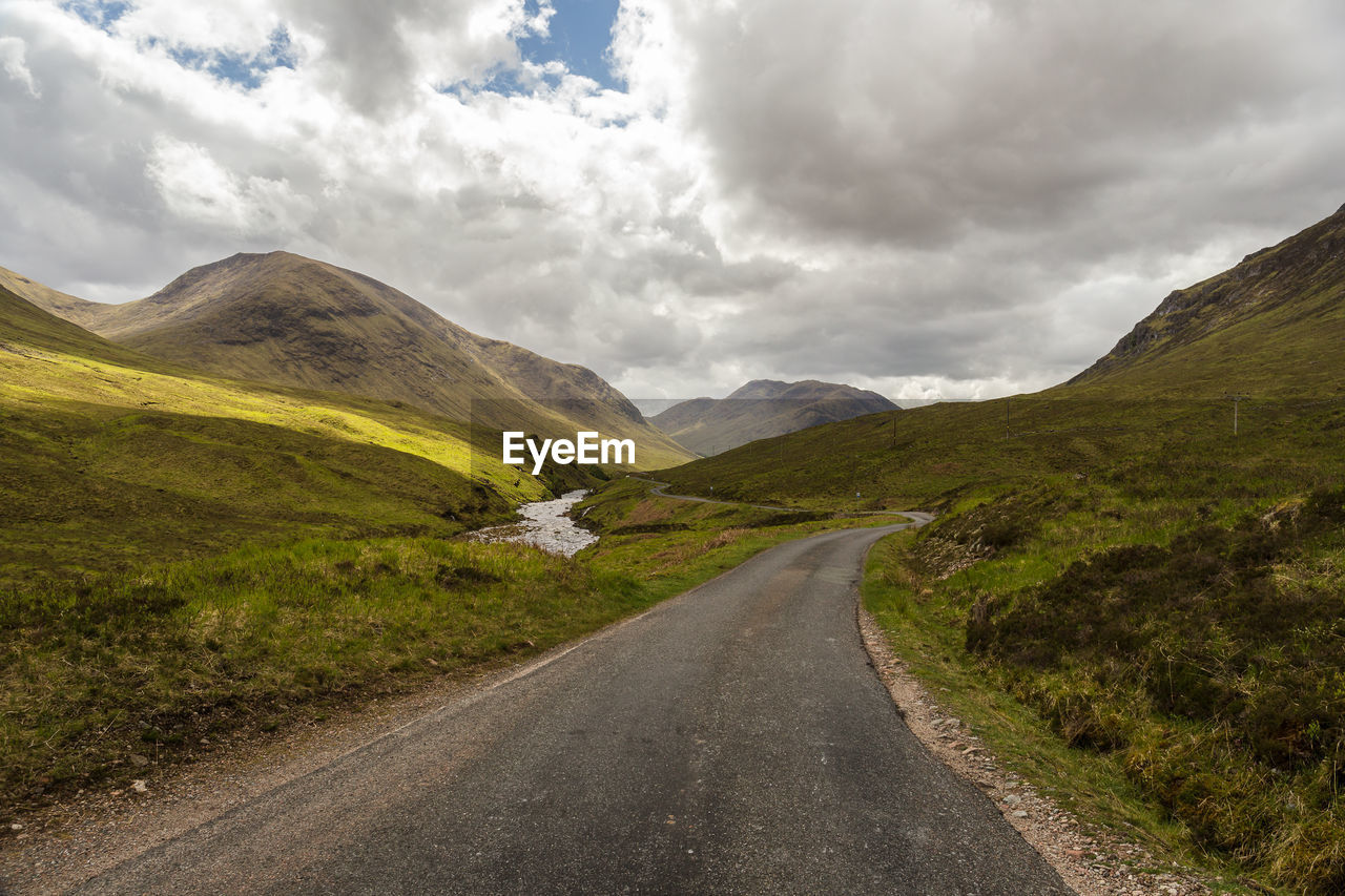 Road amidst mountains against sky