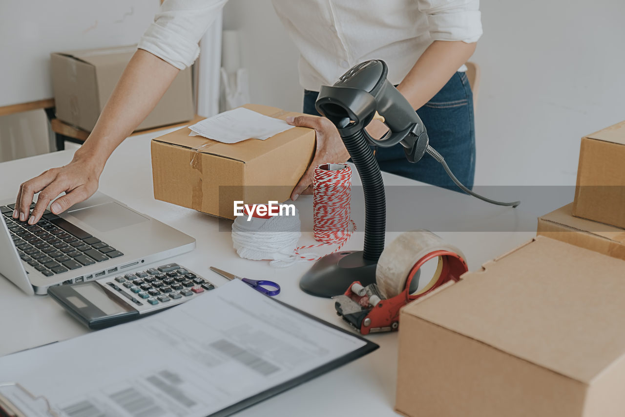 Midsection of businesswoman working on table