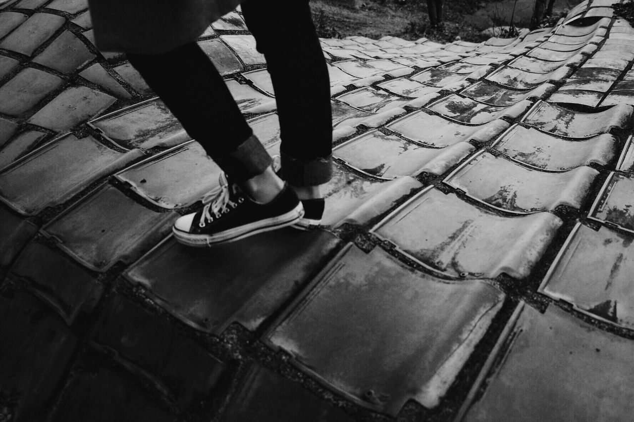 LOW SECTION OF MAN STANDING ON TILED FLOOR