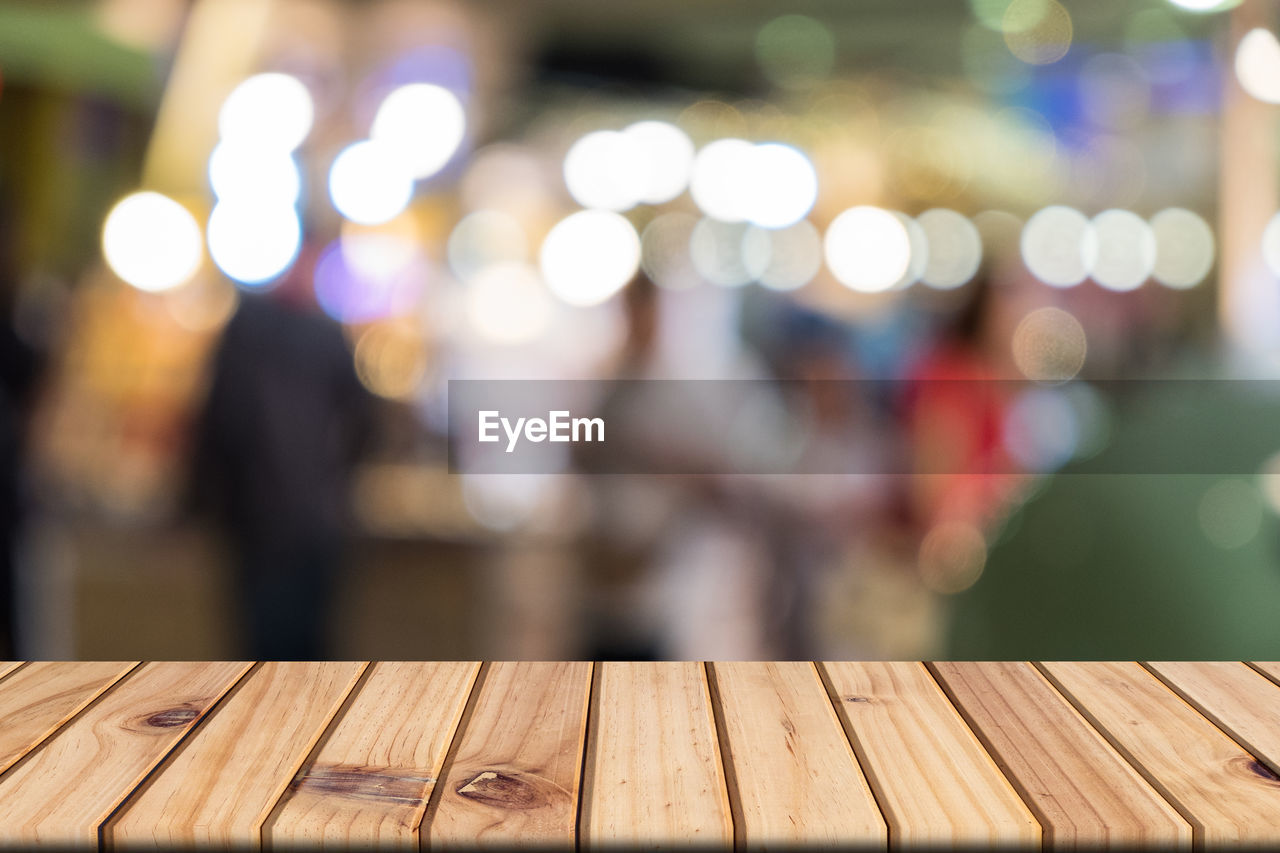 DEFOCUSED IMAGE OF ILLUMINATED BENCH ON TABLE