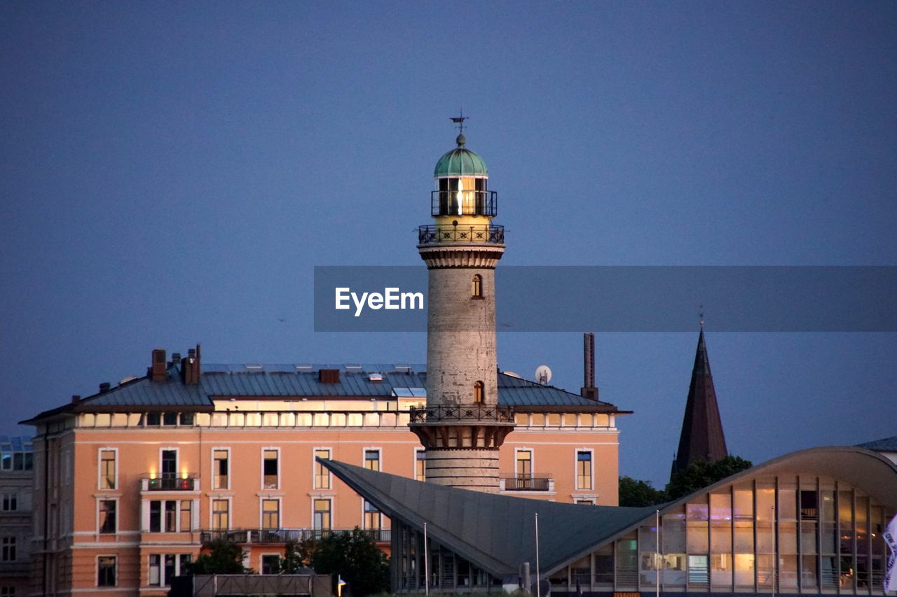 Lighthouse building against sky in city