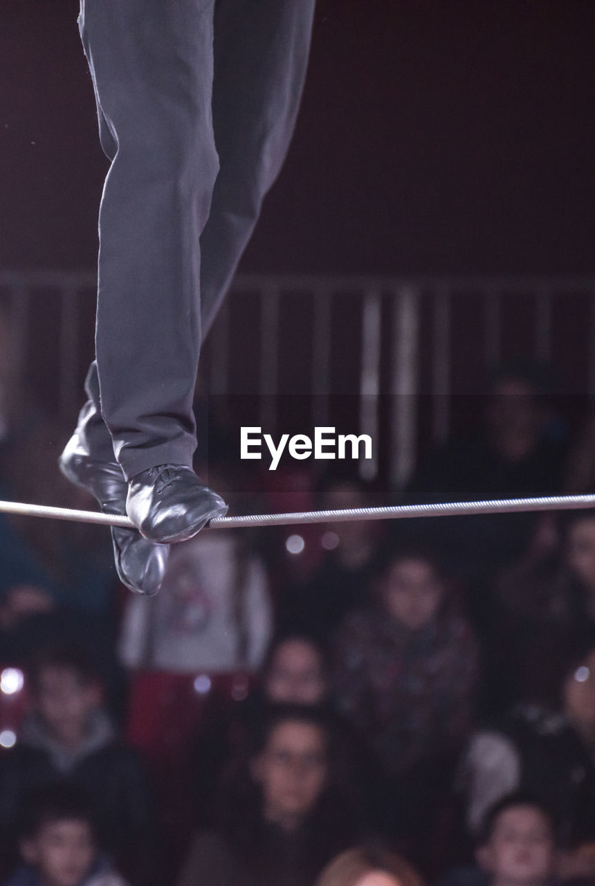 Low section of performer walking on tightrope during event