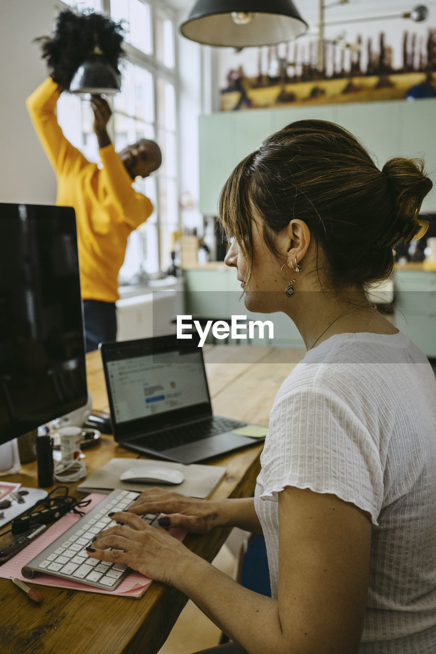 Female freelancer using computer while sitting at table working from home