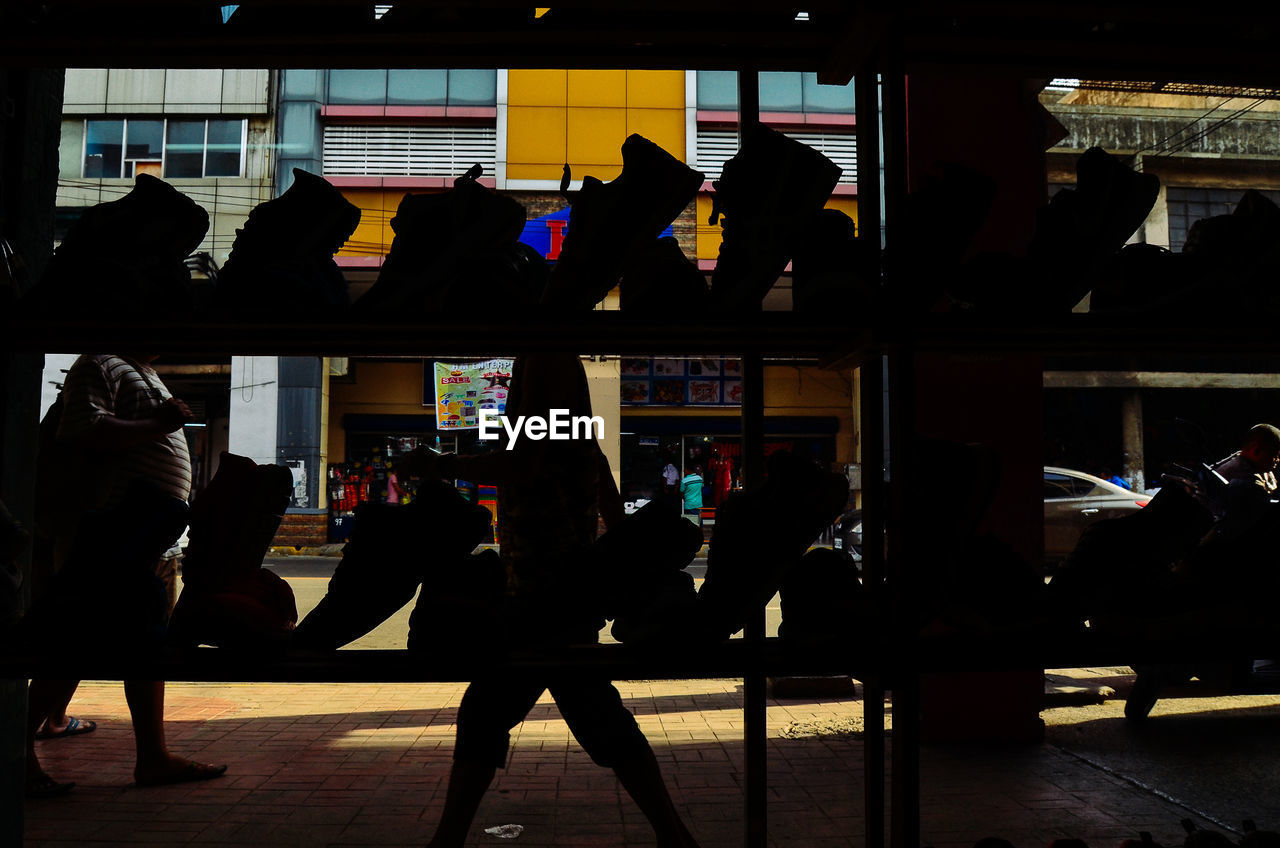 SILHOUETTE PEOPLE WALKING IN FRONT OF STORE