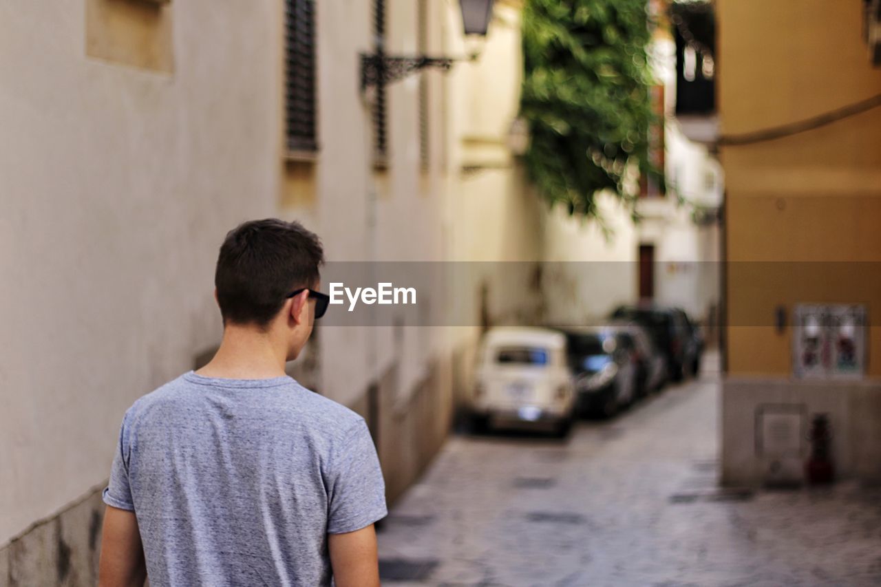 Rear view of man standing at alley