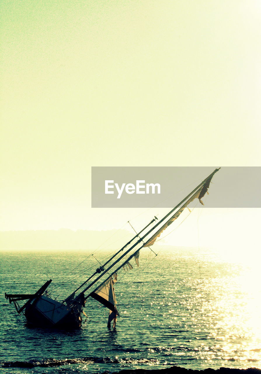 BOAT SAILING IN SEA AGAINST CLEAR SKY