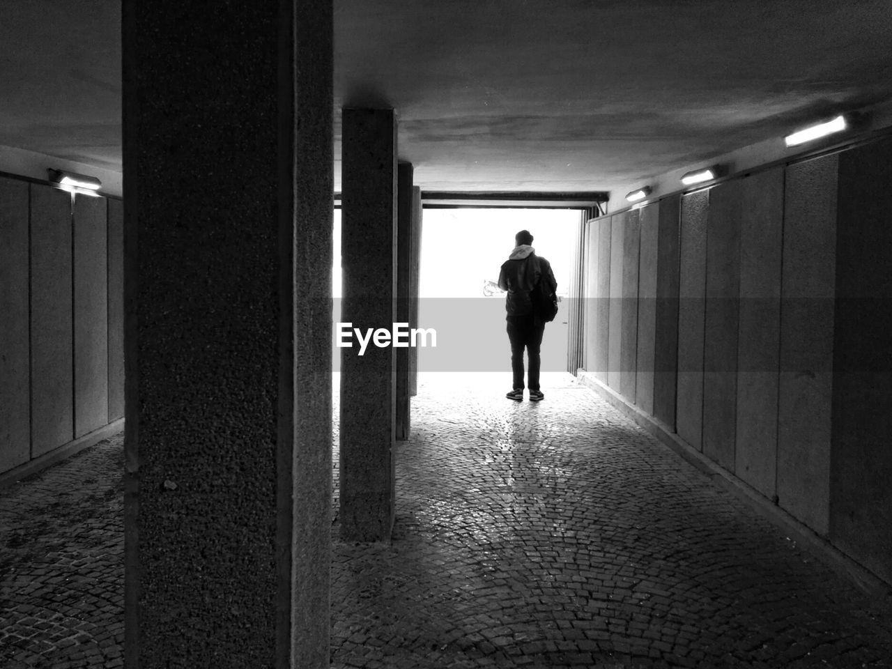 Rear view of man standing in underground walkway