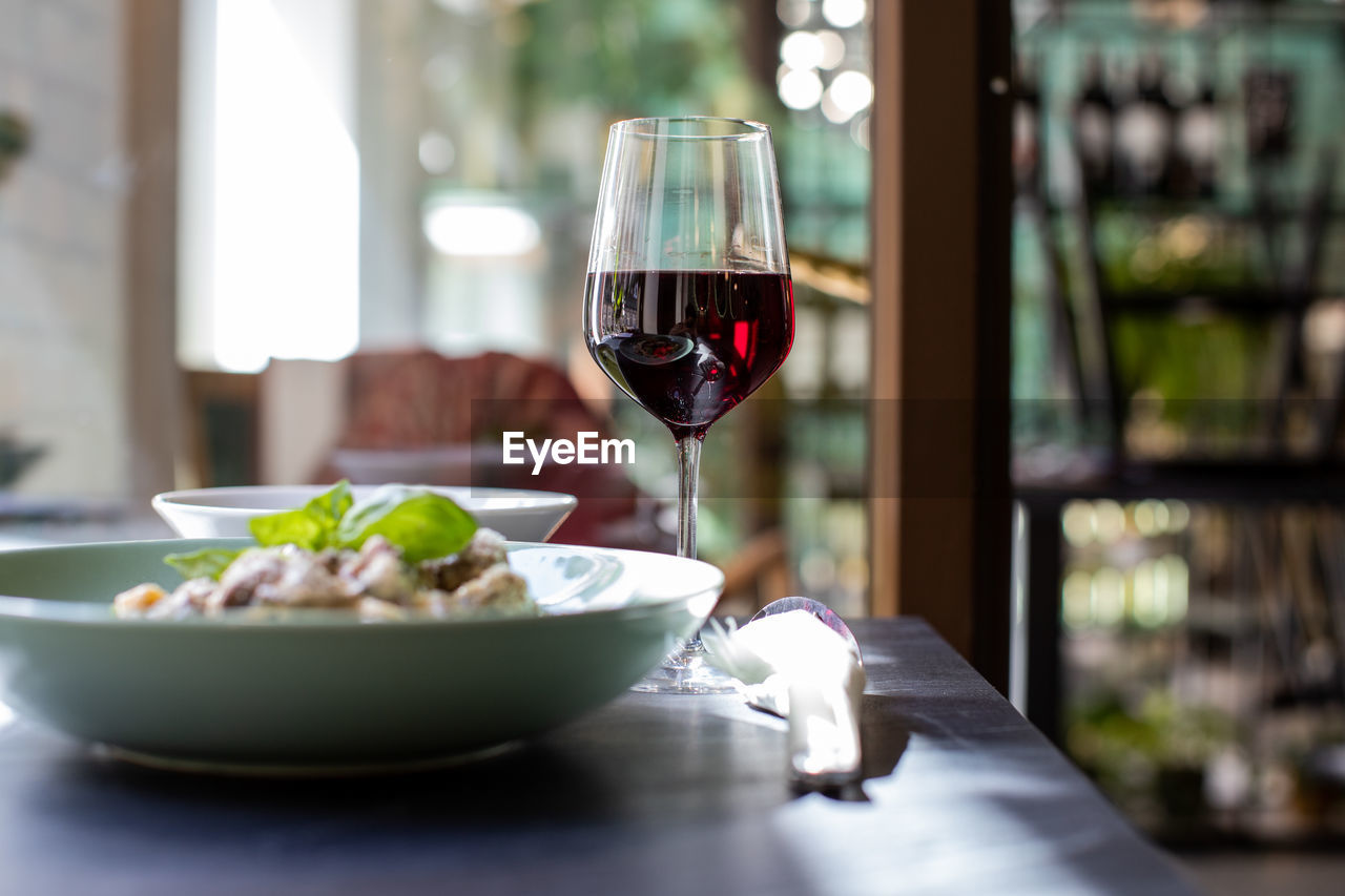 Close-up of red wine and food served on table