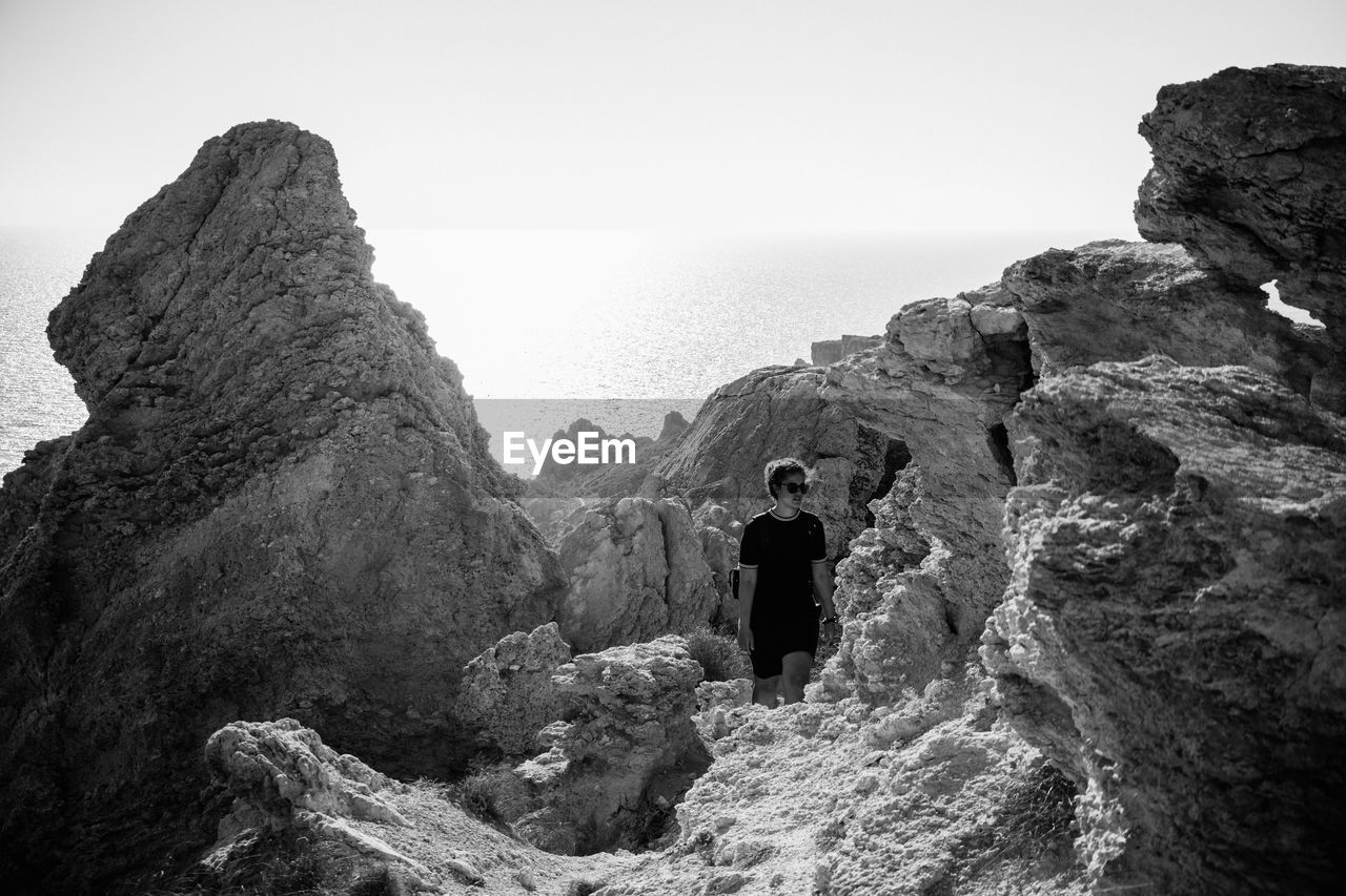 Woman walking on rocky beach