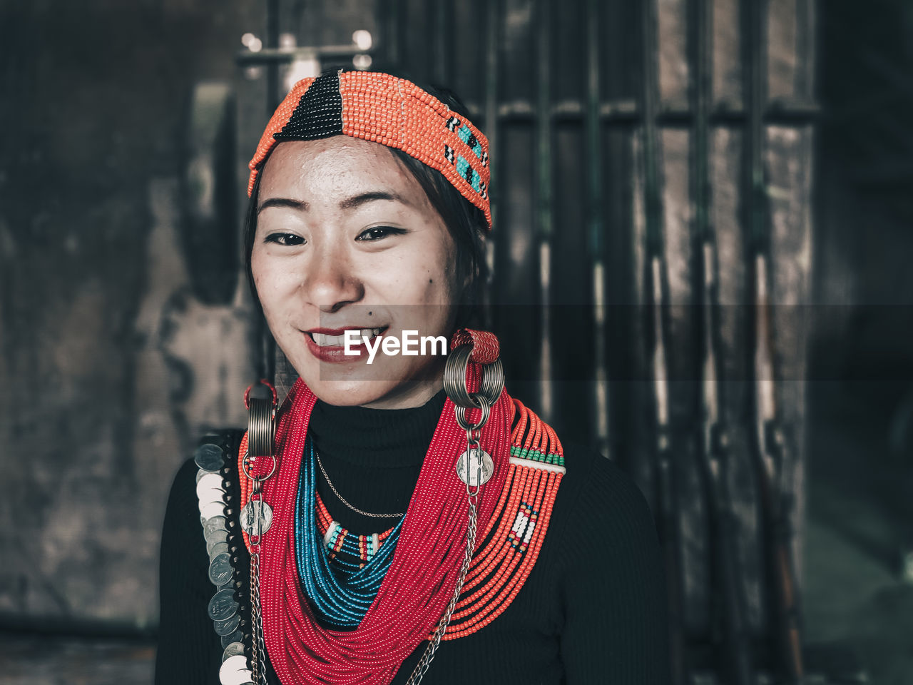 PORTRAIT OF HAPPY YOUNG WOMAN STANDING OUTDOORS