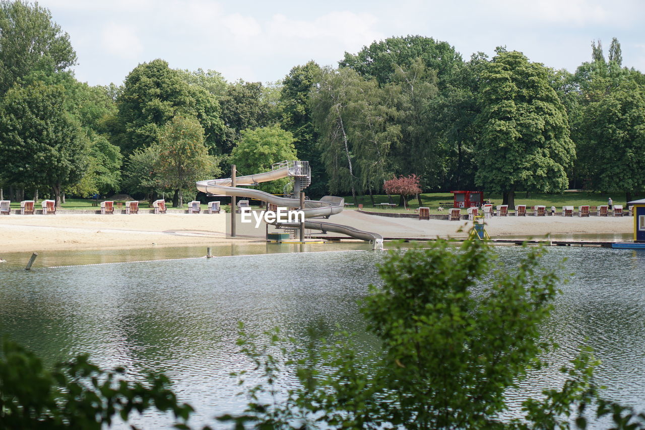 SCENIC VIEW OF TREES BY LAKE AGAINST SKY