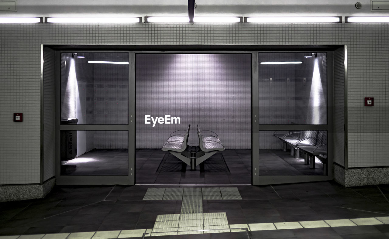 Empty chairs in waiting room seen through doorway