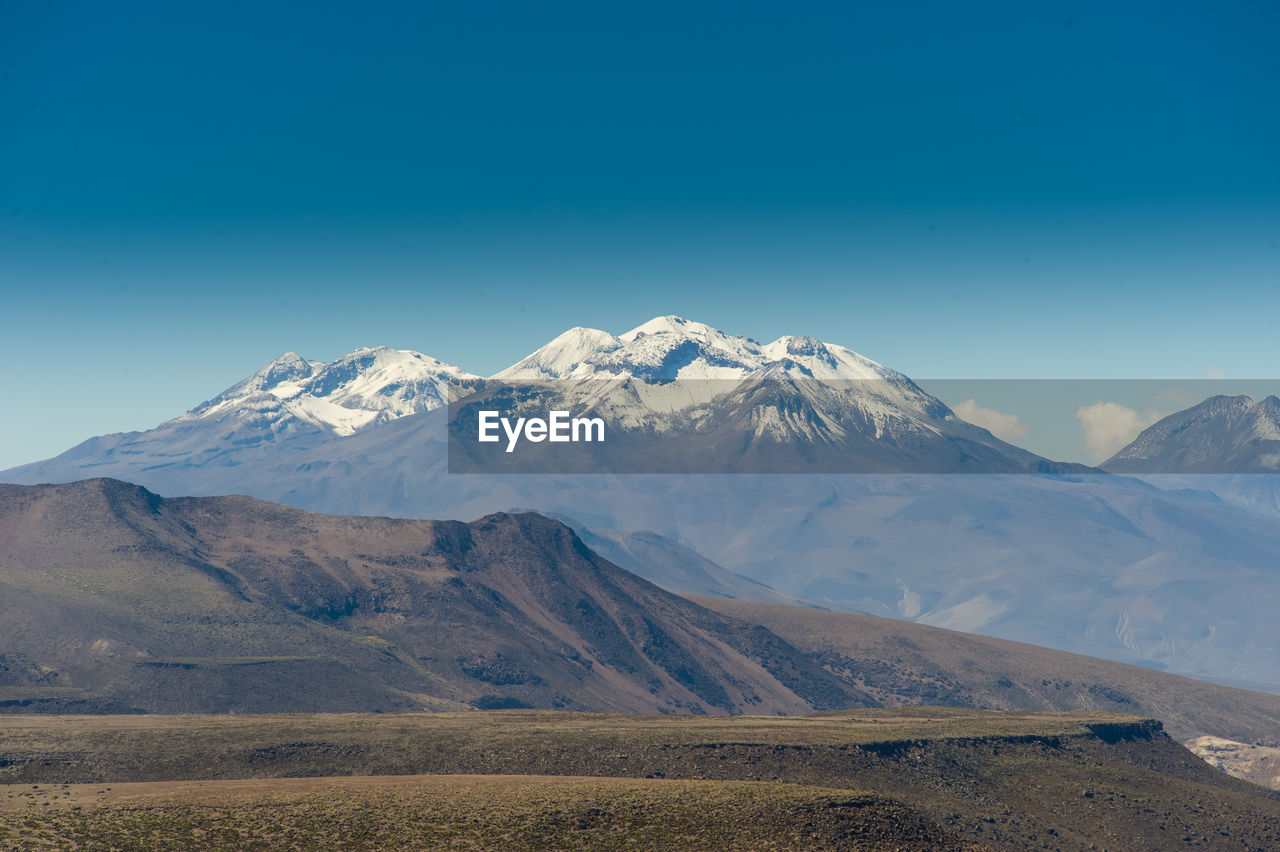 Scenic view of mountains against clear blue sky