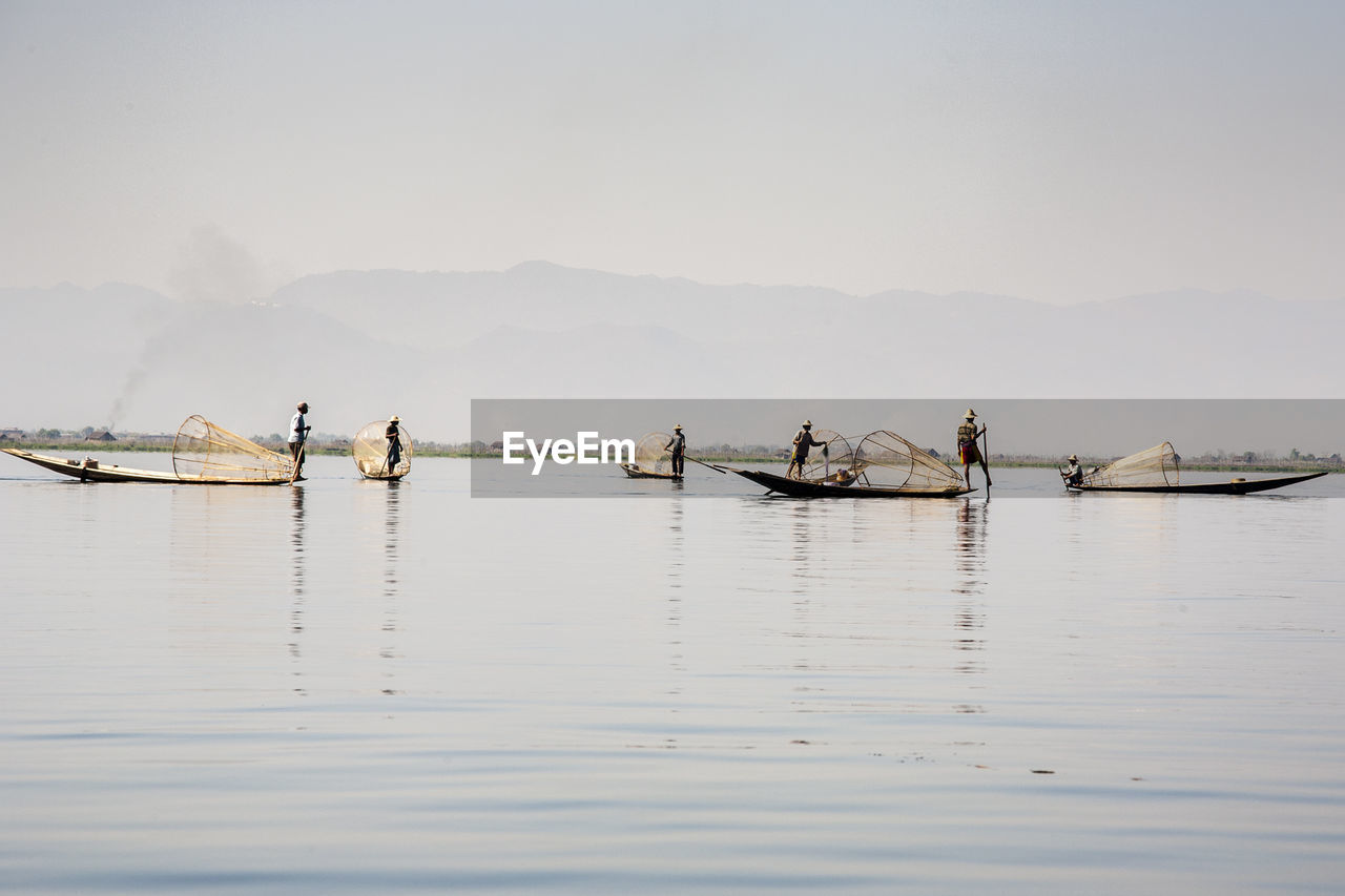 Fisherman fishing on lake in foggy weather