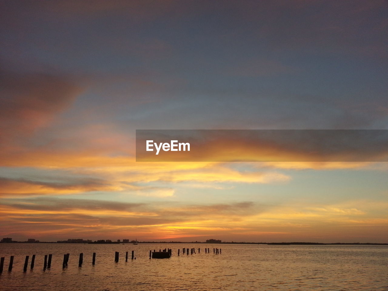 Cloudy sky above lake at sunset