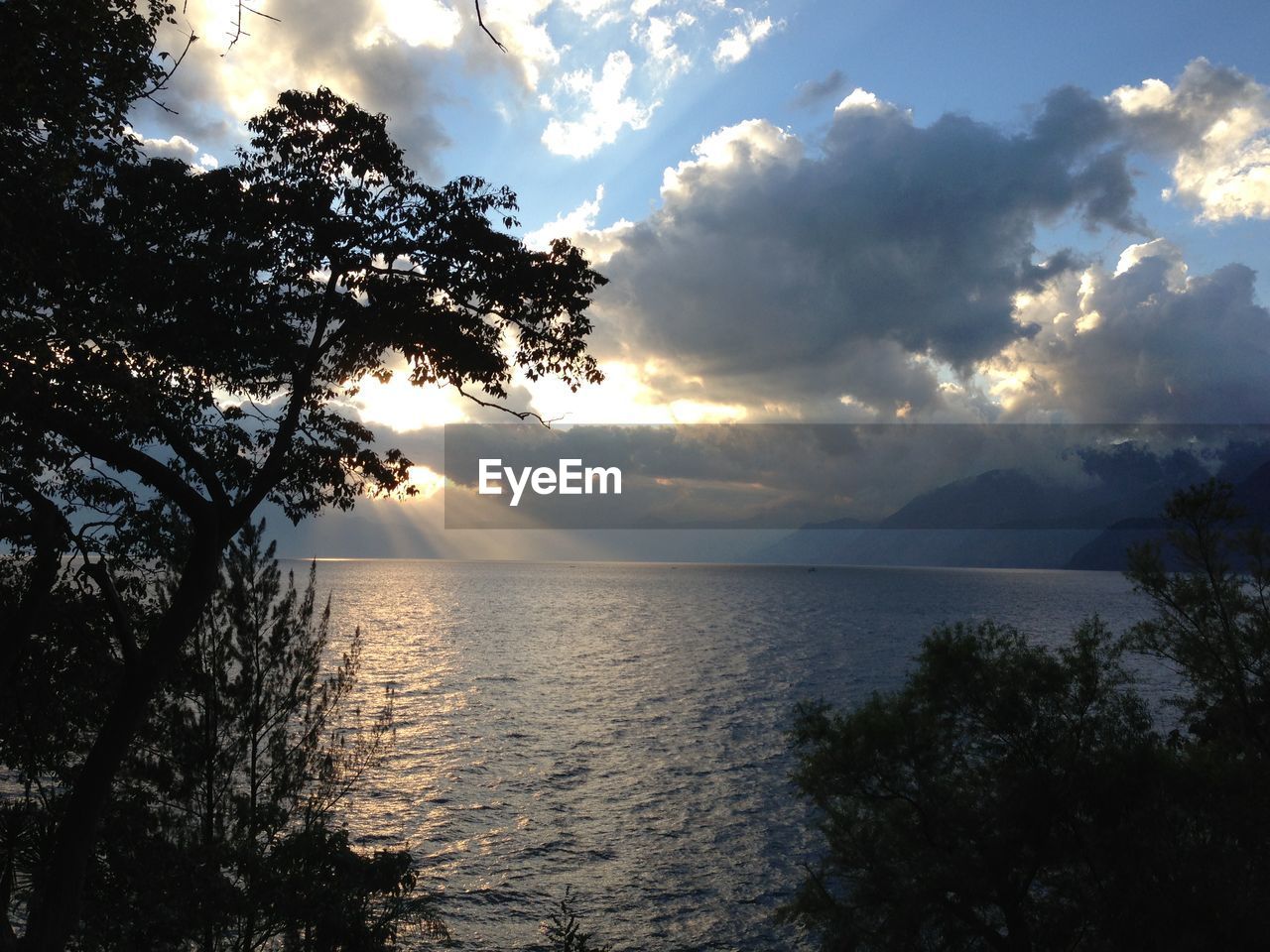 Scenic view of river against cloudy sky