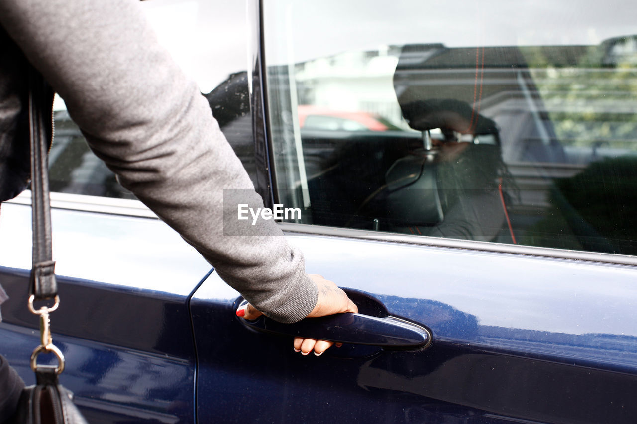 Close-up of hand holding car door handle