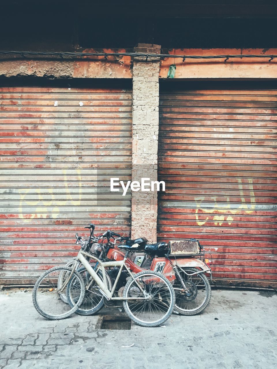 Bicycle and motorcycles in front of garages