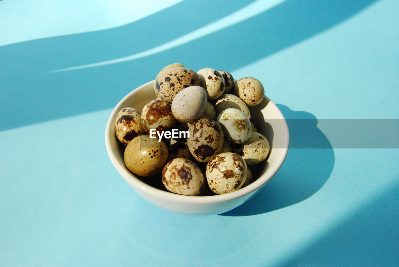 Eggs in bowl over blue background