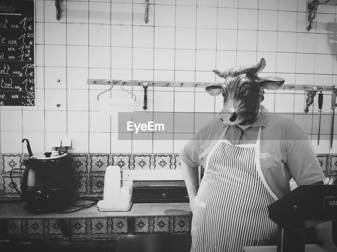 Man wearing animal mask against tiled wall