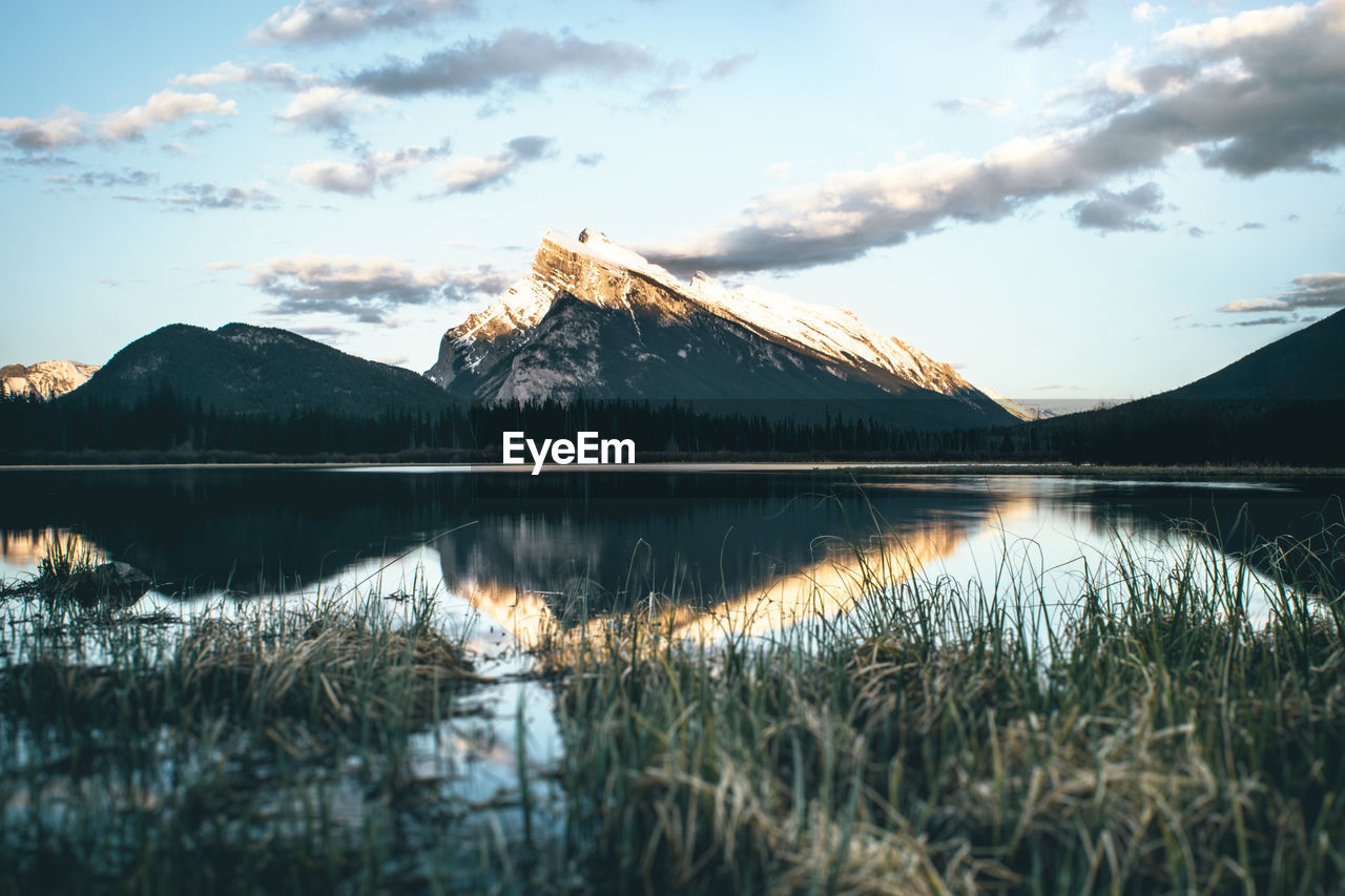 Scenic view of lake by mountains against sky