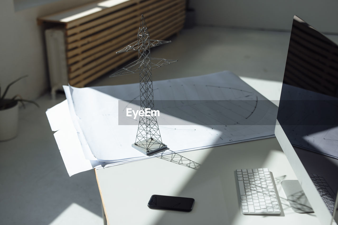 Electricity pylon model and blueprint on desk