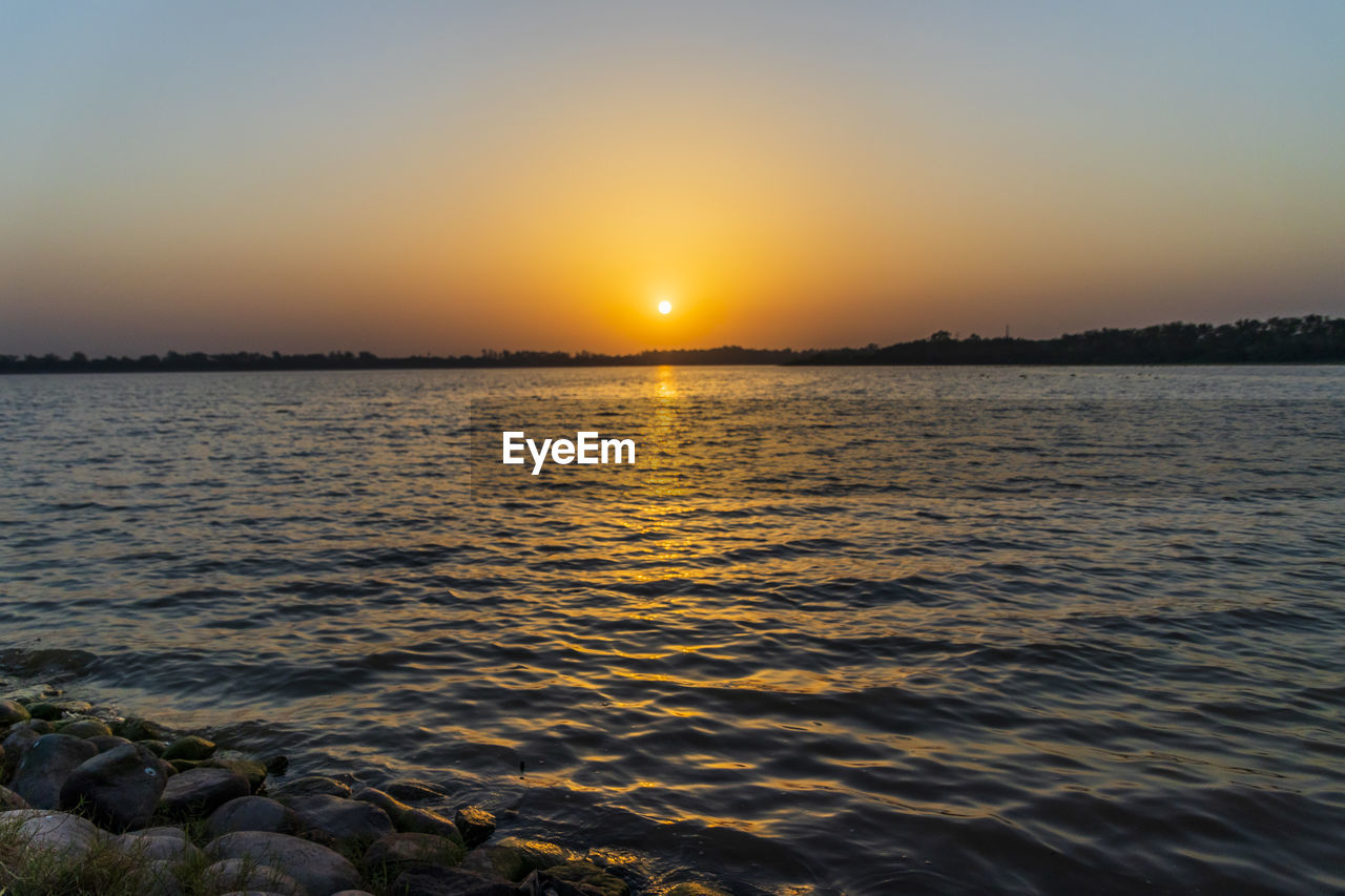 SCENIC VIEW OF SEA AGAINST ORANGE SKY