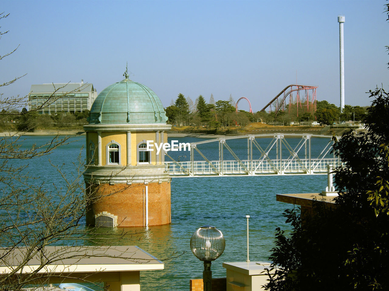 BUILT STRUCTURE BY RIVER AGAINST BUILDINGS