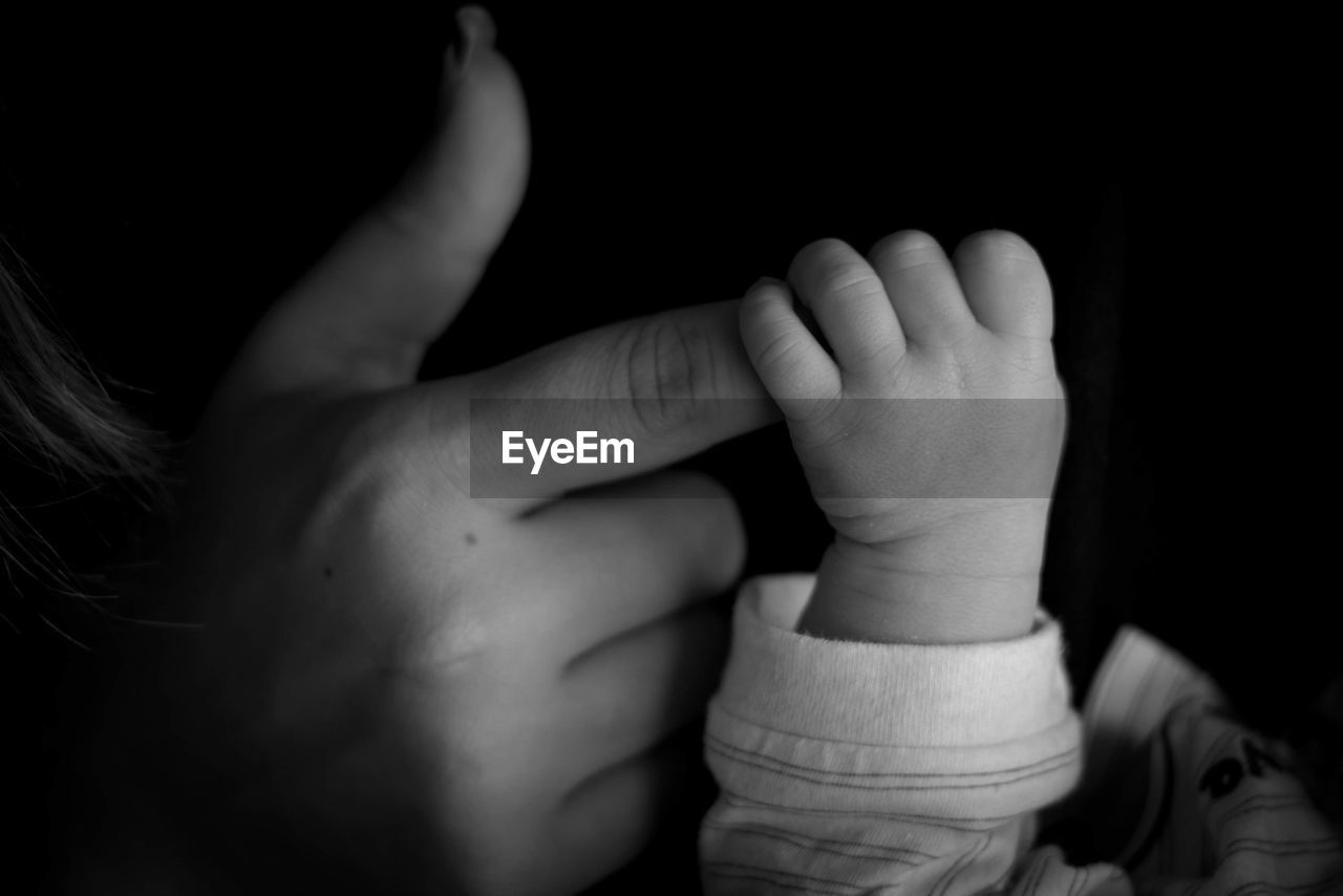 CLOSE-UP OF BABY HAND HOLDING HANDS