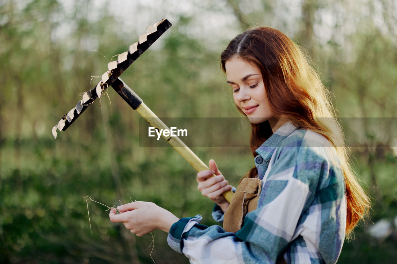 Smiling woman holding rake