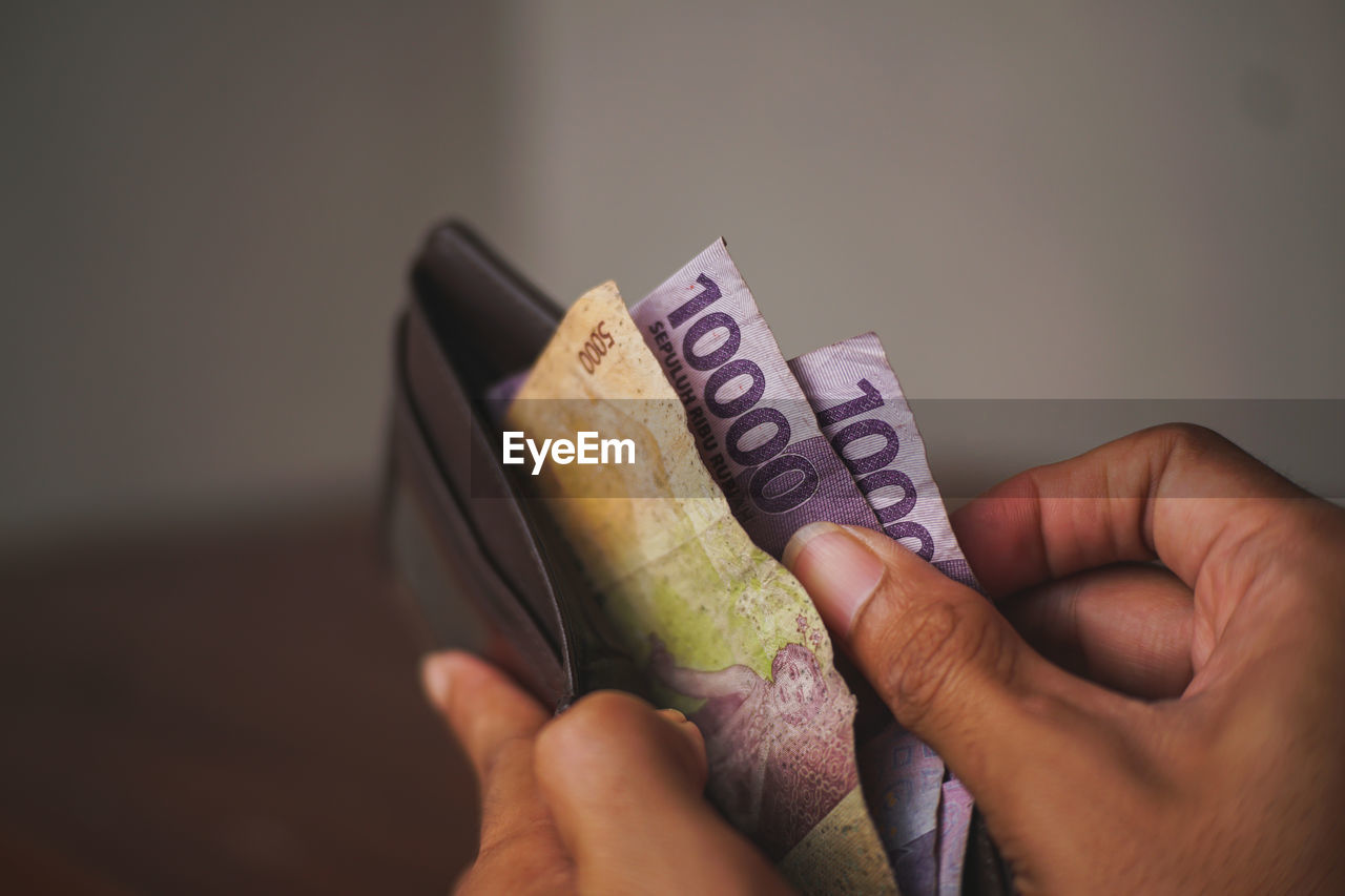 Cropped hand of person holding paper currency