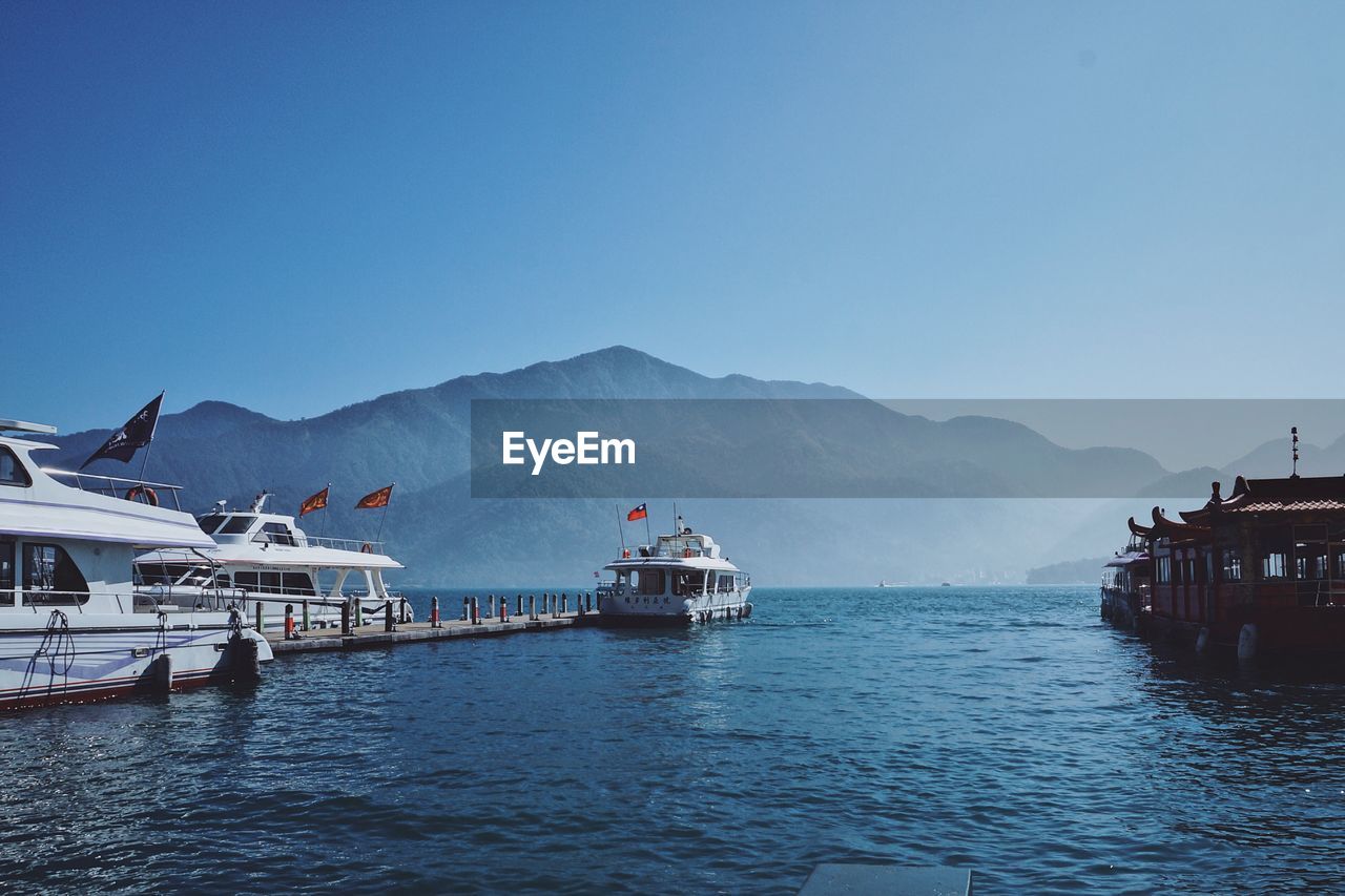 SCENIC VIEW OF SEA AND MOUNTAINS AGAINST CLEAR SKY