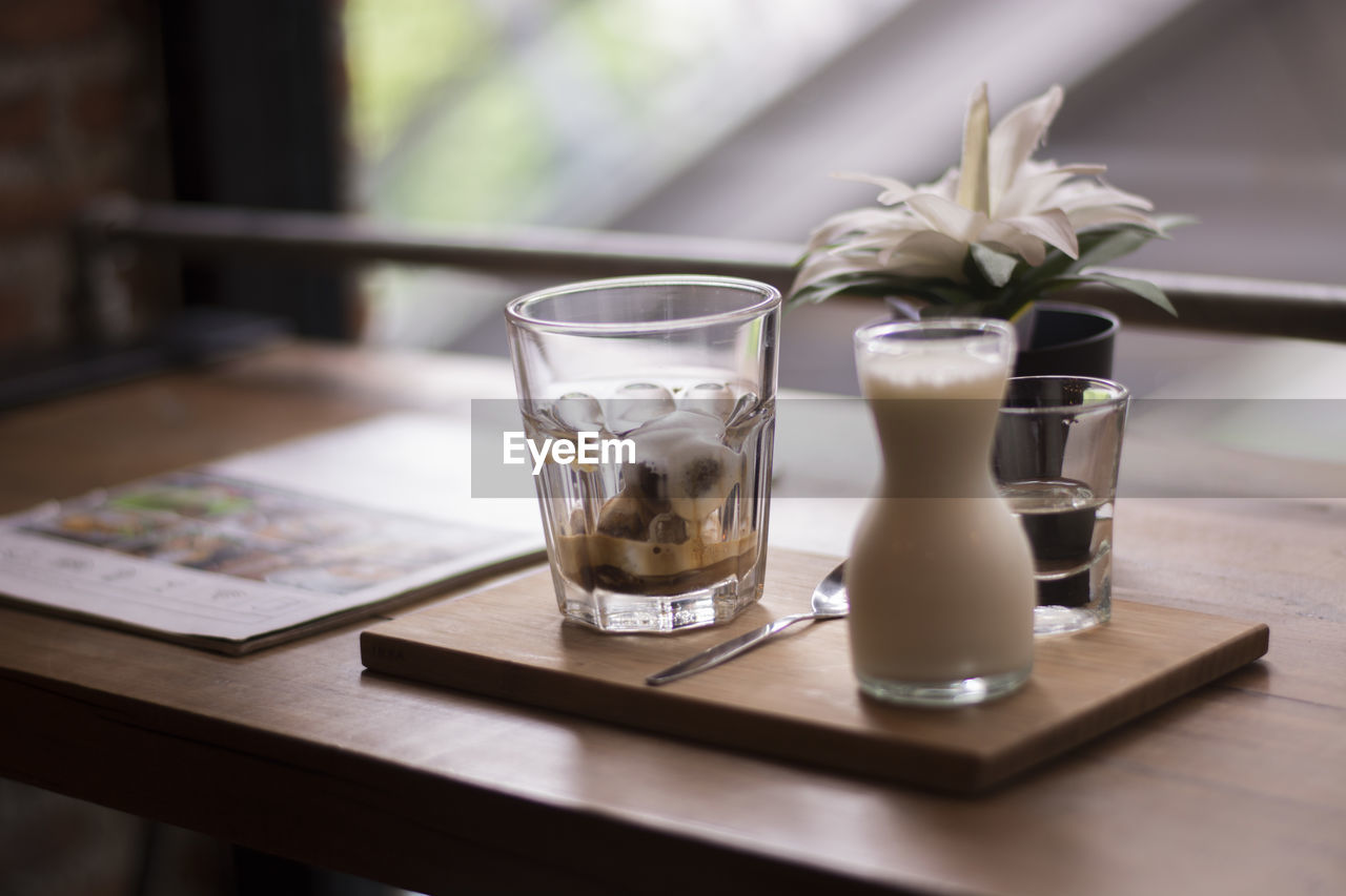 Close-up coffee set with milk on table in cafe